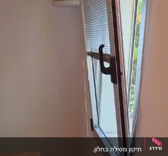תריסים על חלון פתוח עם ידית שחורה